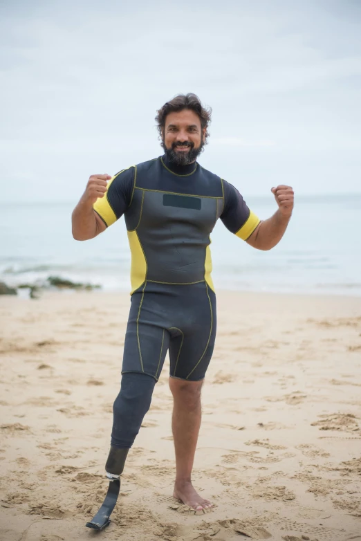 the man is wearing a wetsuit with his arms in the air