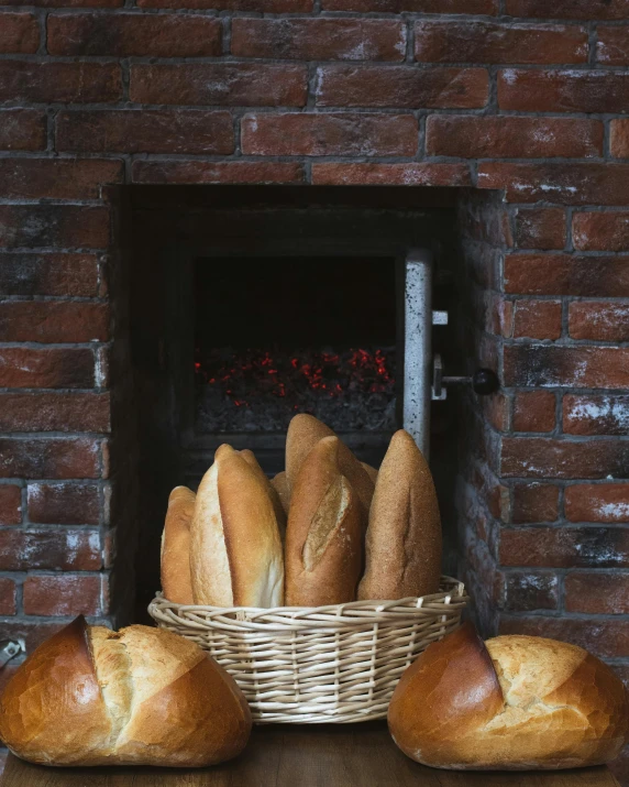 breads in a basket sit in front of a oven