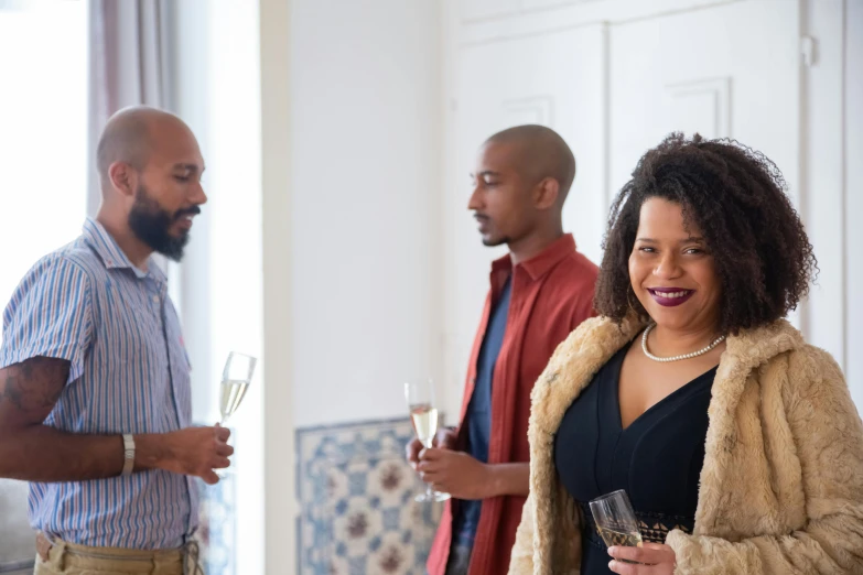 people are standing and having drinks at a party