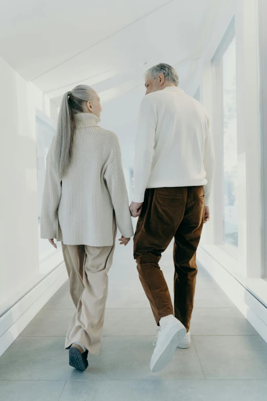 two people walking down the hall holding hands