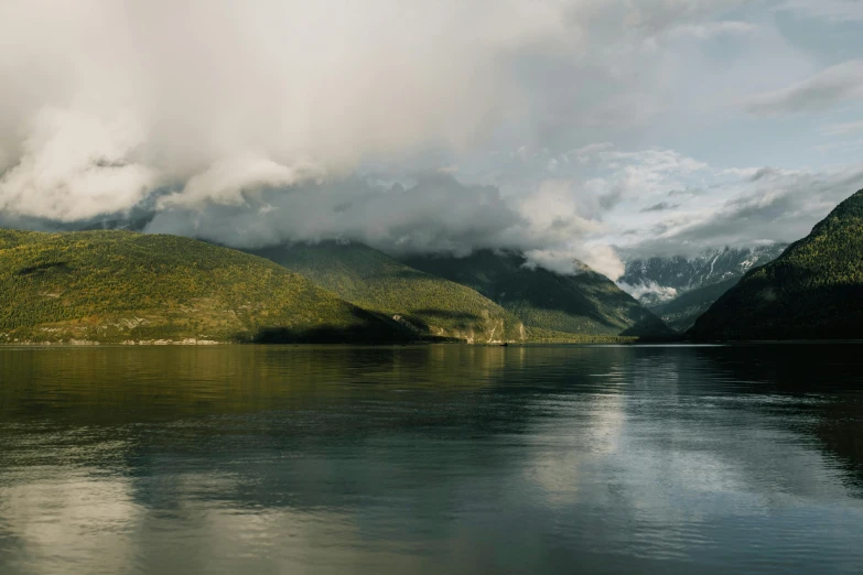 a very cloudy sky hangs over some mountains