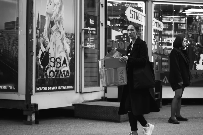 some women walking down a city street by store windows