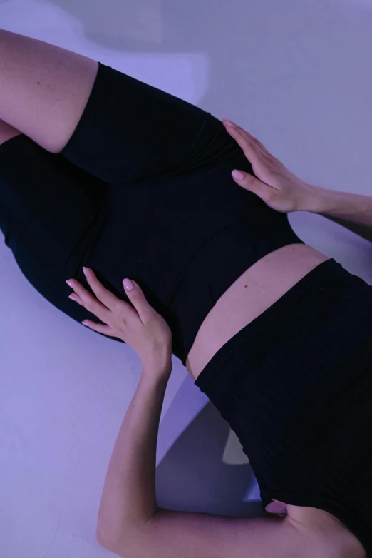 a woman in a tight black shirt and black skirt is lying down