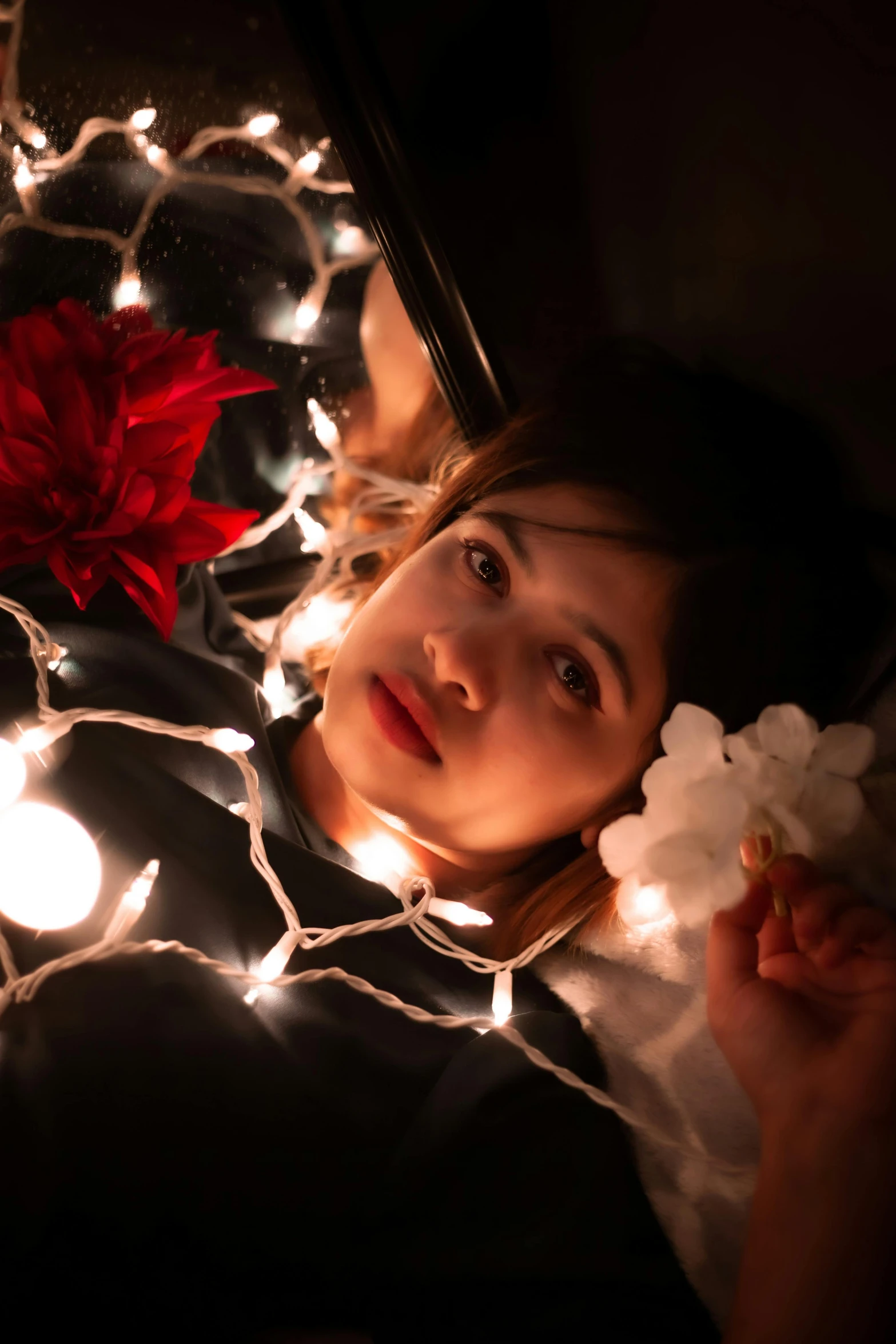 a little girl is sitting under a christmas light