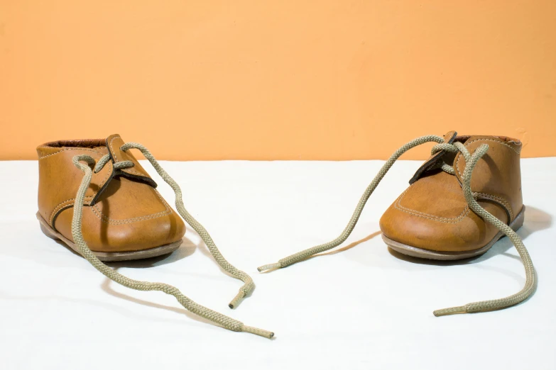 two brown shoes with laces on top of each boot