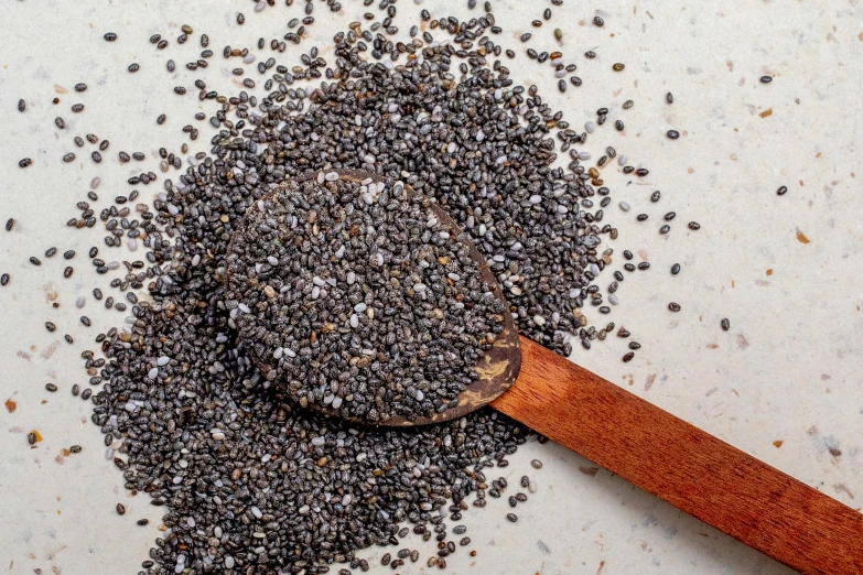 a scoop full of ground pepper flakes with a wooden spoon