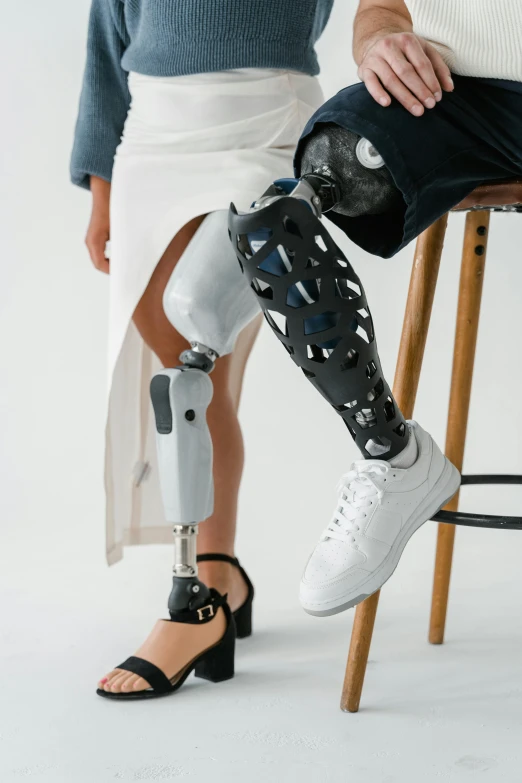 a man with white socks sitting on a stool in front of a woman's leg