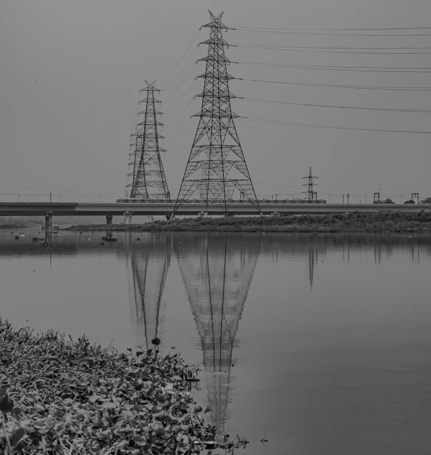 electric pylons sitting next to a body of water