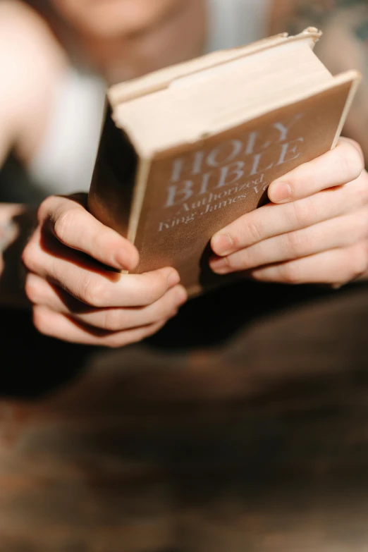 a hand holding an old bible, showing the front cover