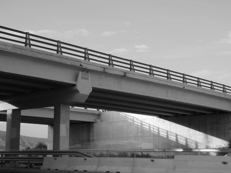 a person standing under a large bridge over water