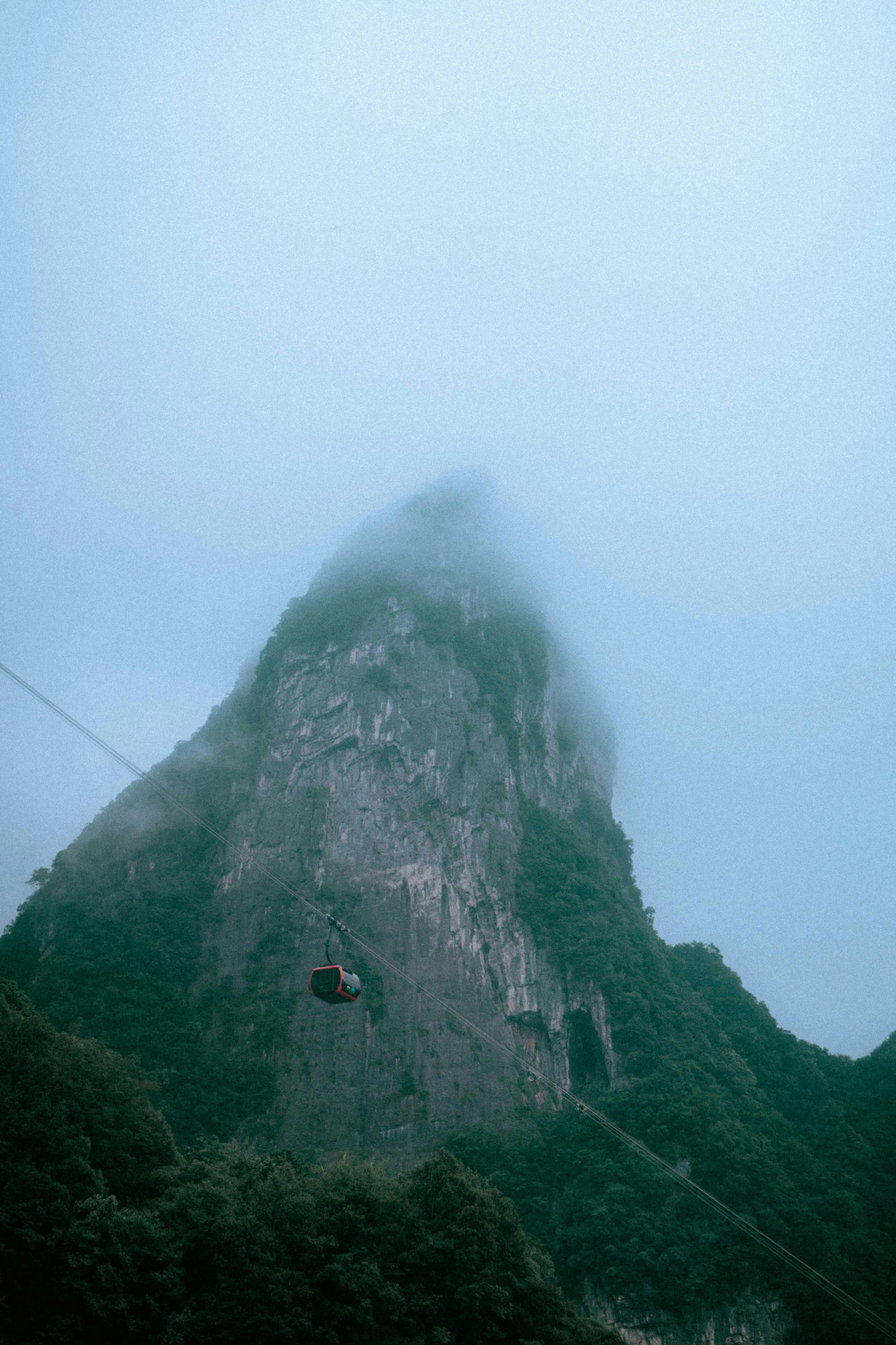 a mountain in the clouds and some trees