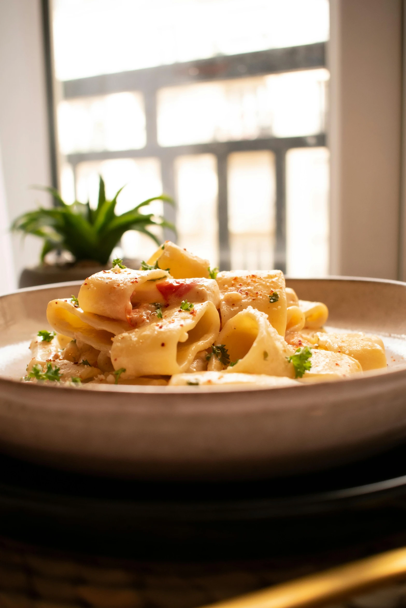 pasta, including meat and parsley on a brown plate