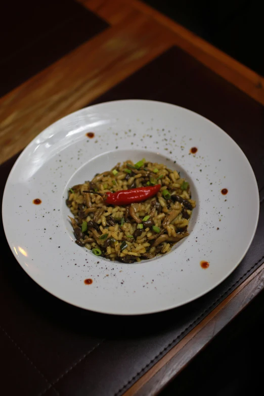 a white plate of food with a red pepper