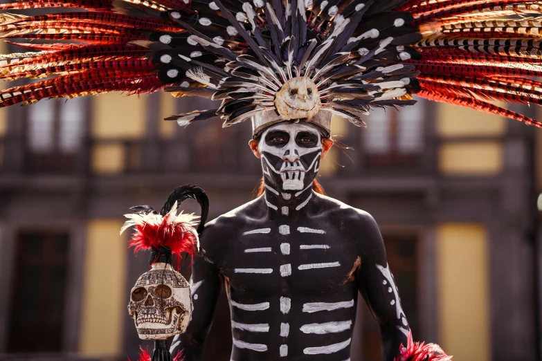 a woman with a skeleton body and headdress holds a decorative object