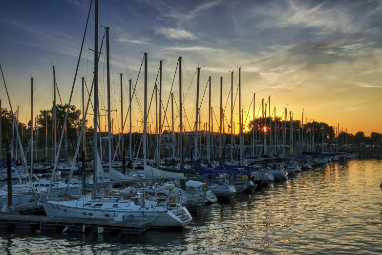 sailboats parked in a harbor at sunset