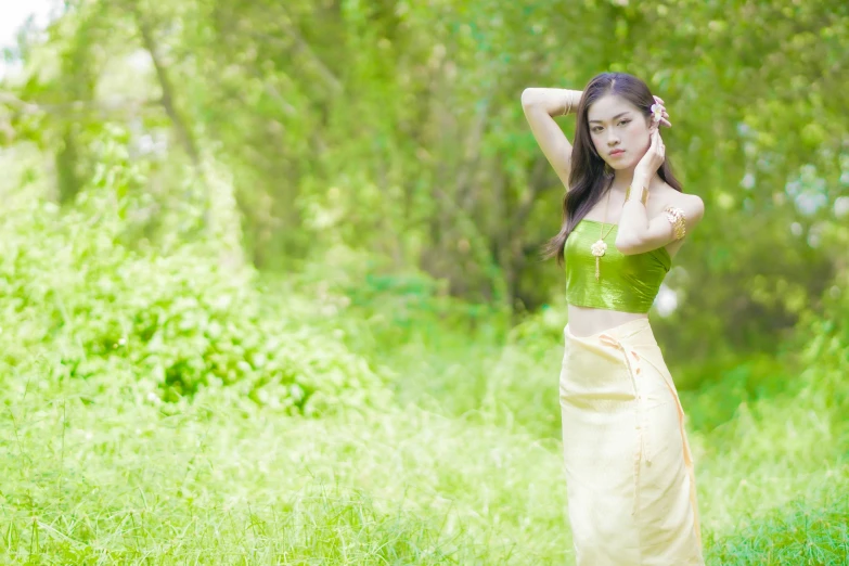 a beautiful young woman standing in a grassy field