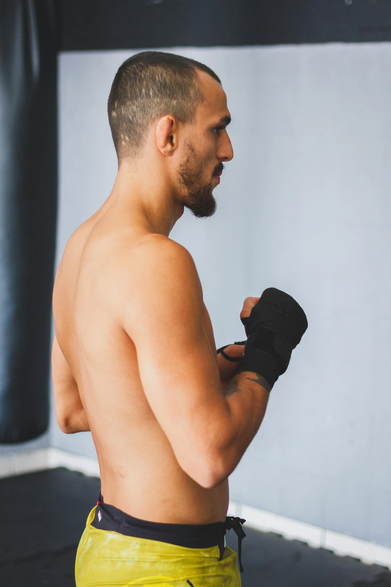 the shirtless man is getting ready to kick the boxing glove