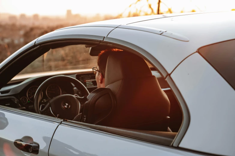 the driver of a white sports car looks back at the pographer