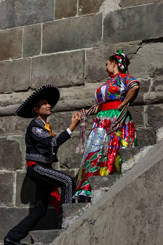 two people dressed in mexican gauchos near some stairs