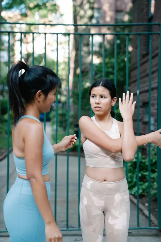 two girls are dancing together with one standing