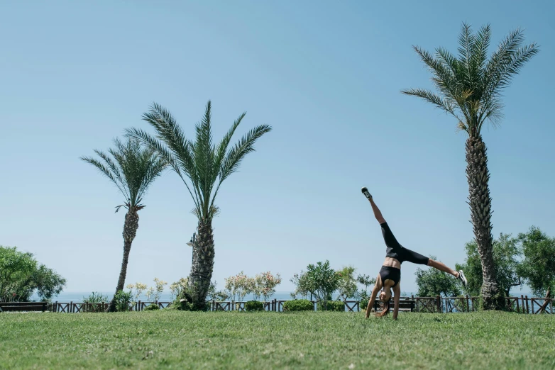 the man is in a park doing a handstand