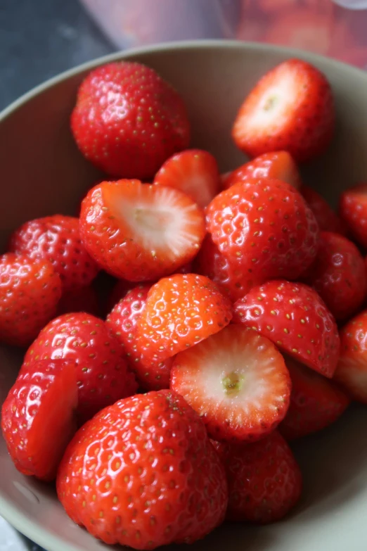 a bowl full of strawberries sits on a table