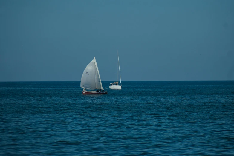 two small sail boats on calm blue waters