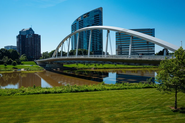 a white bridge in the middle of a grassy area