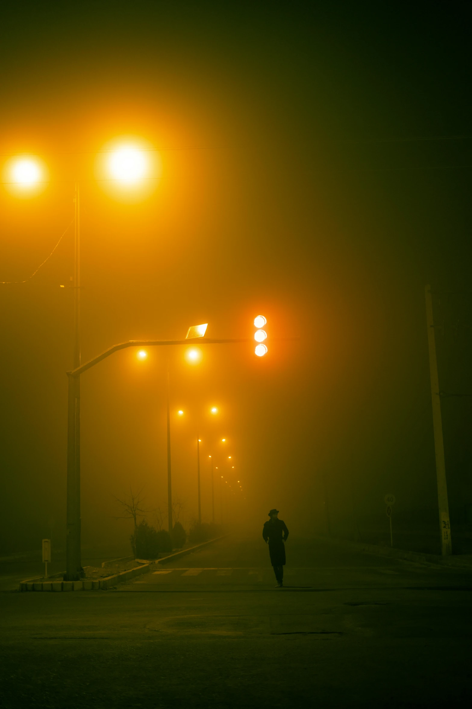 two lights on the street above a foggy intersection