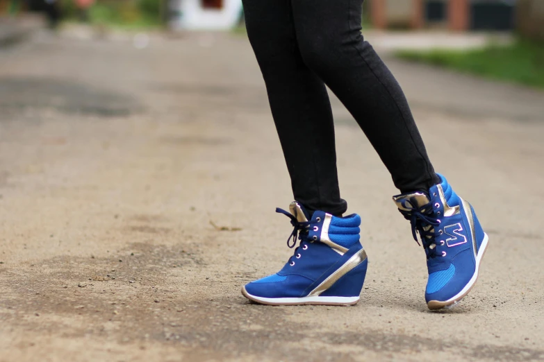 a person wearing sneakers stands in the middle of a road