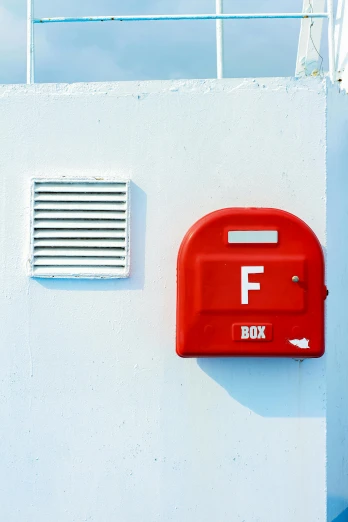 a red box attached to a wall near a window