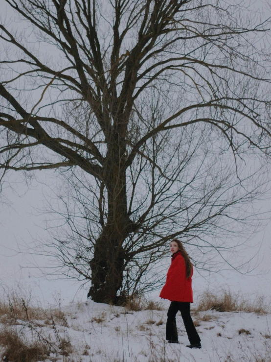 a woman in a red jacket walking in the snow