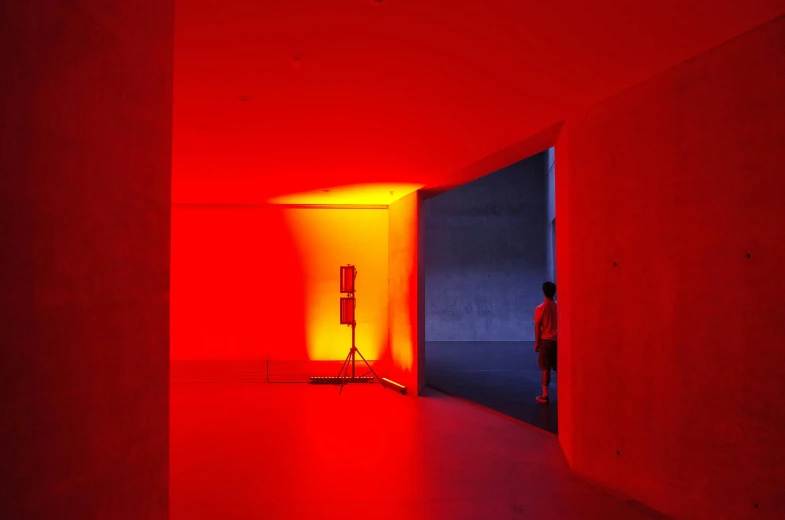 a person in red light is looking in an empty room