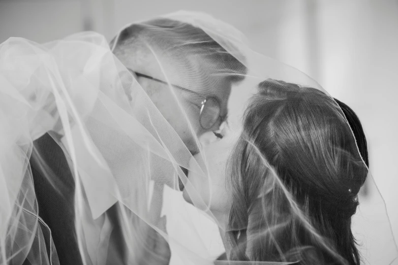 a close up view of two people dressed in wedding attire, with veils covering them