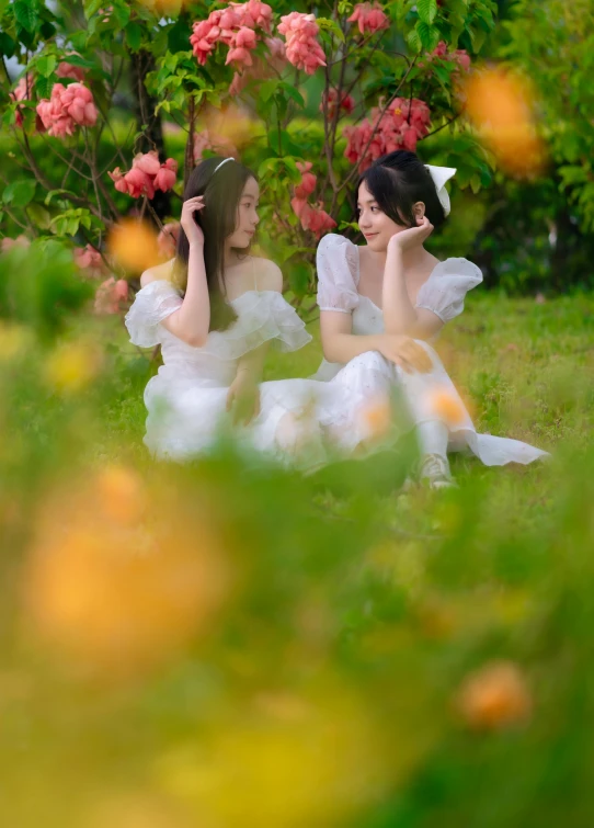 two women sit next to each other outside