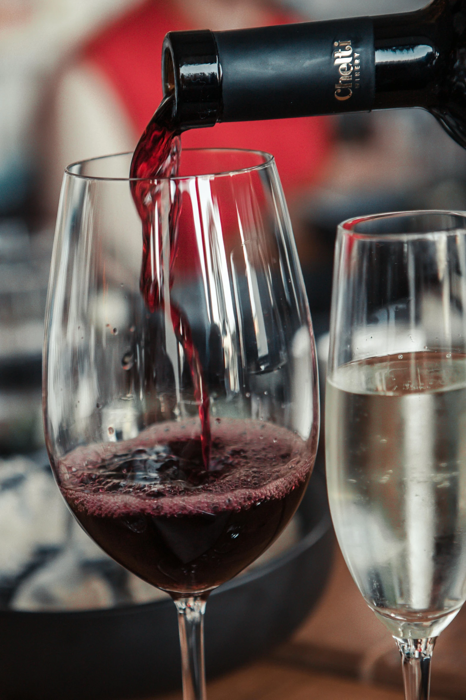 red wine being poured into a glass by an object