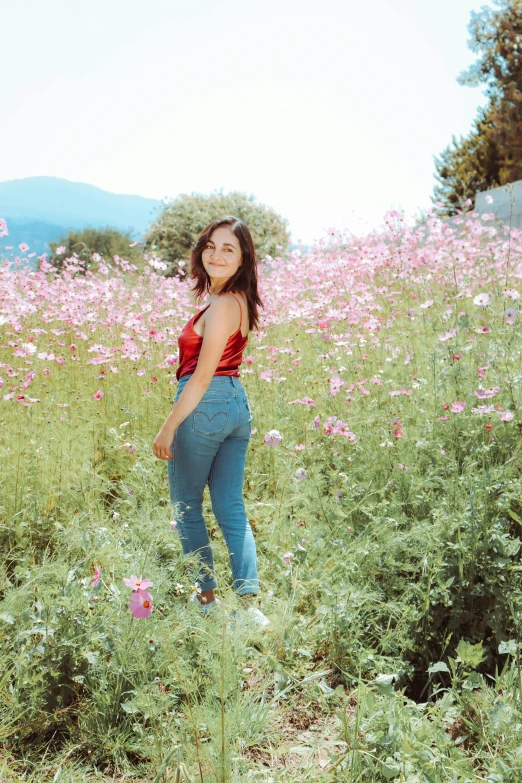 a woman standing in tall grass posing for a po