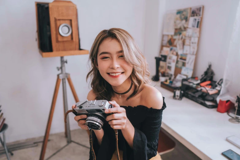 a girl is smiling and taking a picture with her camera