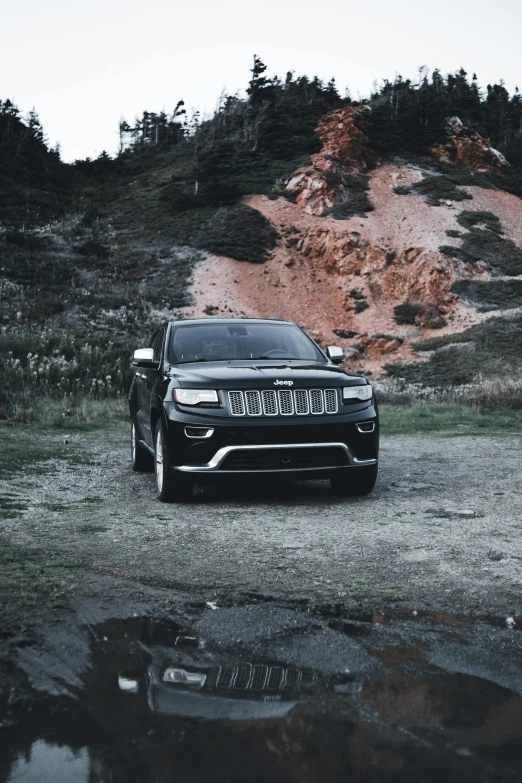 a black car is parked near some rocks