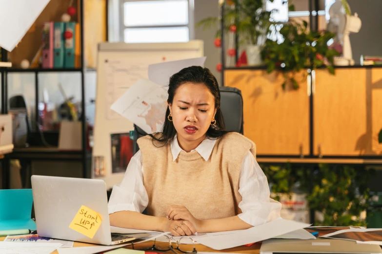 a woman is reading a document and making a face