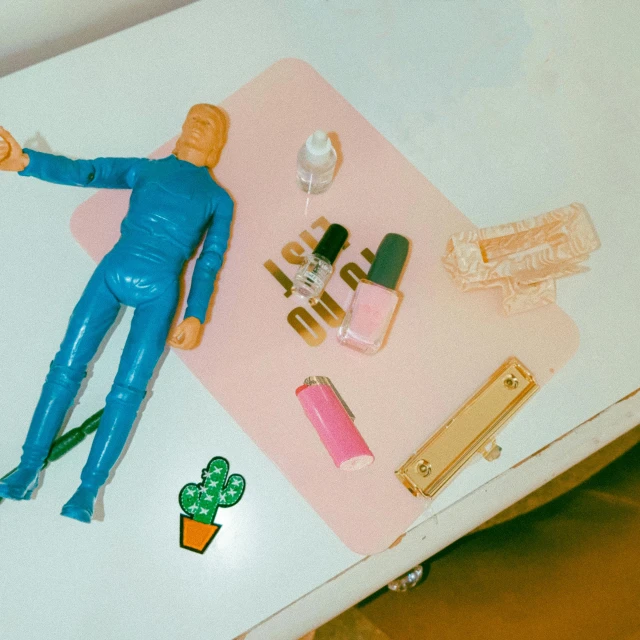 a toy man lying on top of a bed near two jars