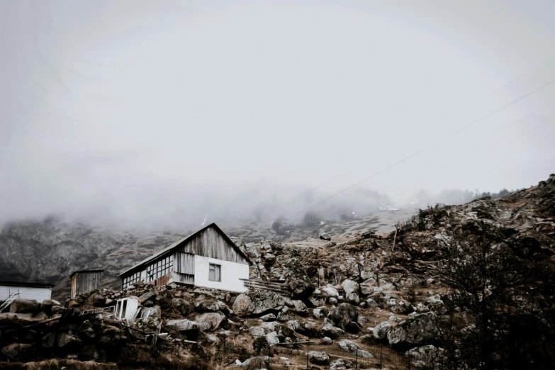 a house on top of a mountain surrounded by fog