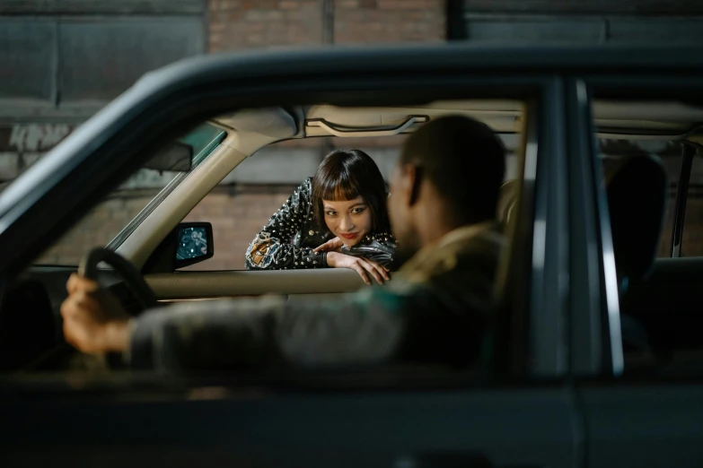a woman with her hands on her lips sitting in the drivers seat of a vehicle