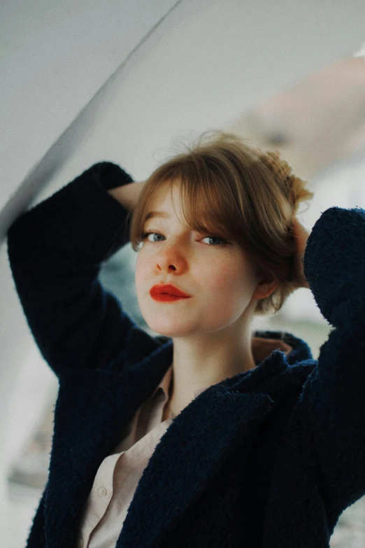 a woman wearing a black jacket leaning on the wall