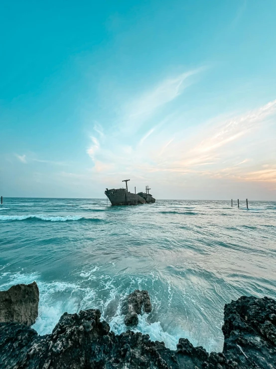 a large ship sailing over a rocky shore