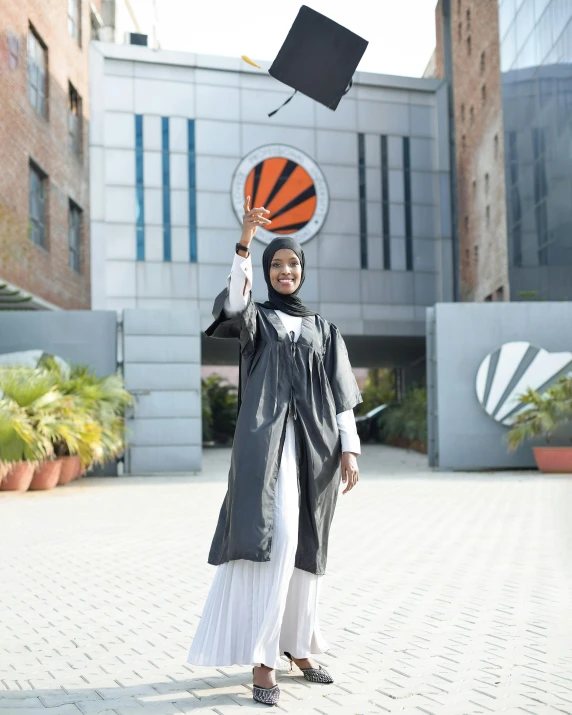 a woman in a graduation gown throws her mortar