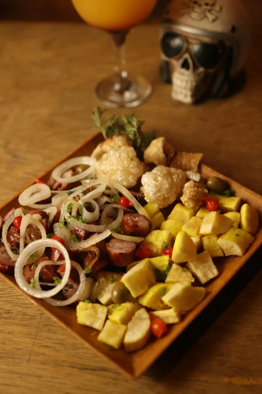 food and drink on wooden table with skull in background