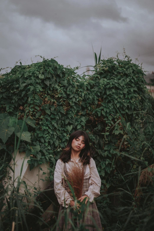 a woman is standing in a forest looking at soing