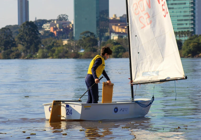 a person on a small boat with a sail