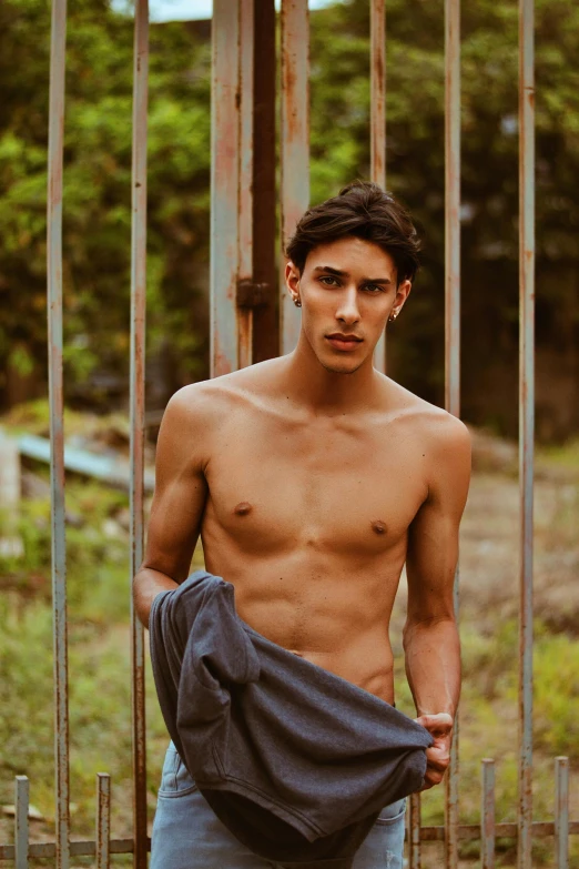 young  guy standing in front of an iron gate